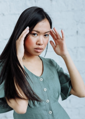 A picture of a young adult Asian woman who looks overwhelmed