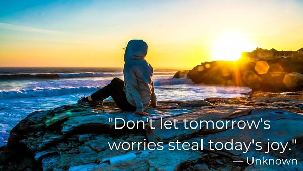 Woman in a hoodie at the ocean with quote: “Don’t let tomorrow’s worries steal today’s joy.”  – Unknown